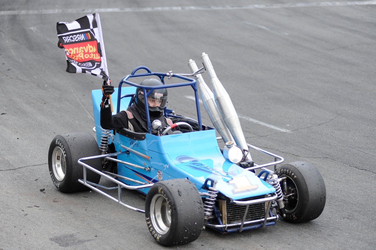 Checkered flag time. Tyler Wagner, the winner of the vintage division, takes a victory lap at the speedway.